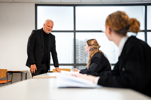 Beveiliger in opleiding in leslokaal met docent NRS