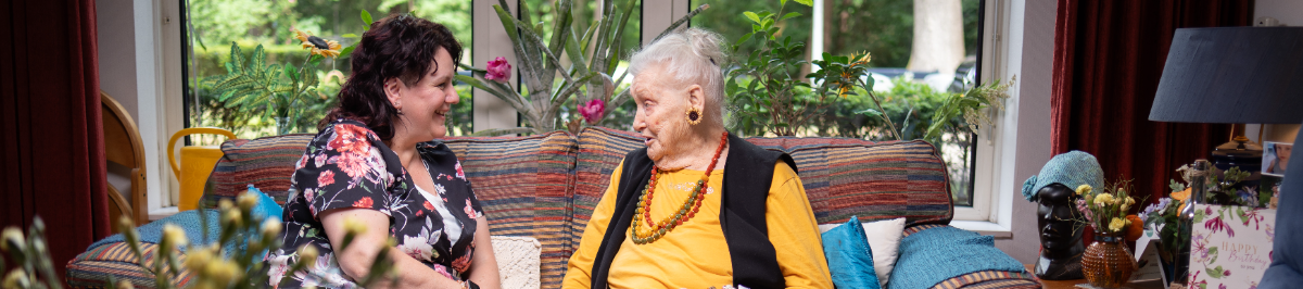 Medewerker in gesprek met bewoner in de kamer van de bewoner.